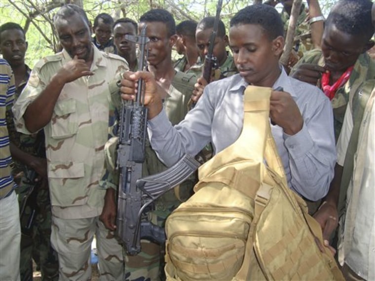 Somali government forces show off the gun and hand luggage that were retrieved from the body of Fazul Abdullah Mohammed, June 8.